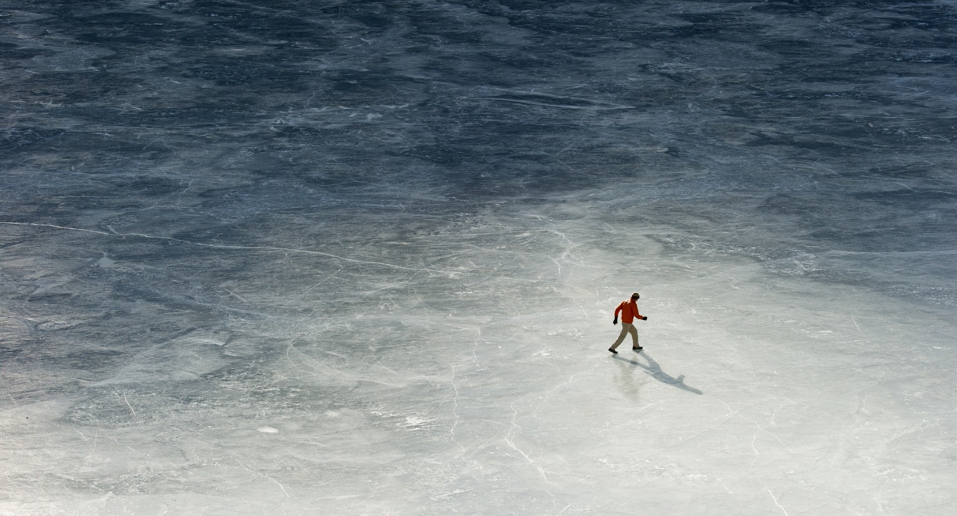 Man ice-skating over a frozen lake.